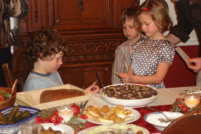 A girl sharing the opłatek wafer with her brother