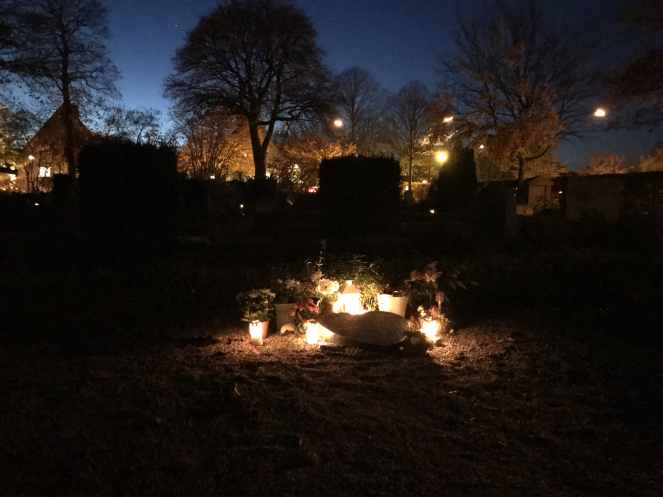 candles alight a grave in Sweden